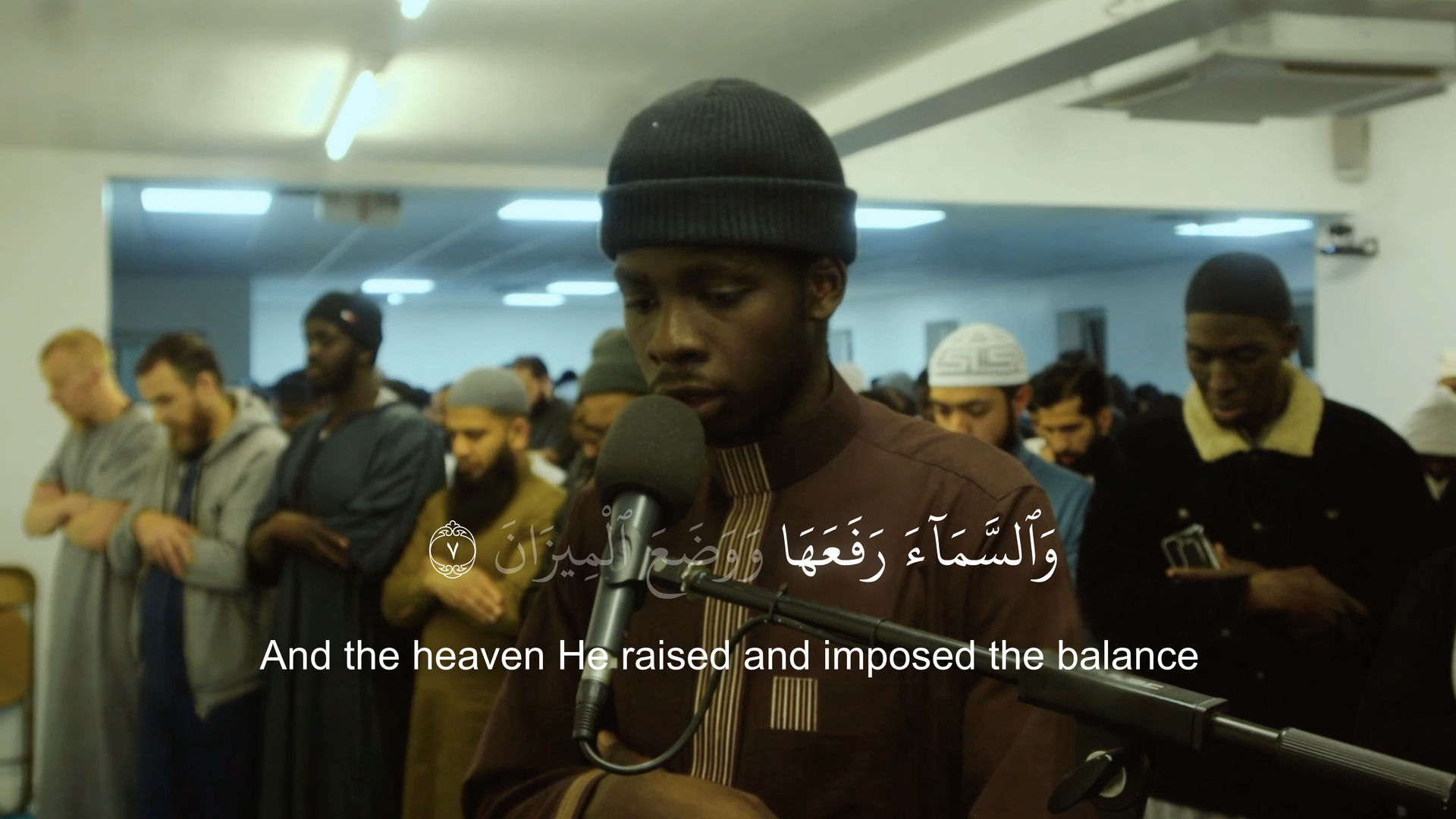 Exported frame: the reciter with Surah Ar-Rahman 55:7 in Arabic and its English translation